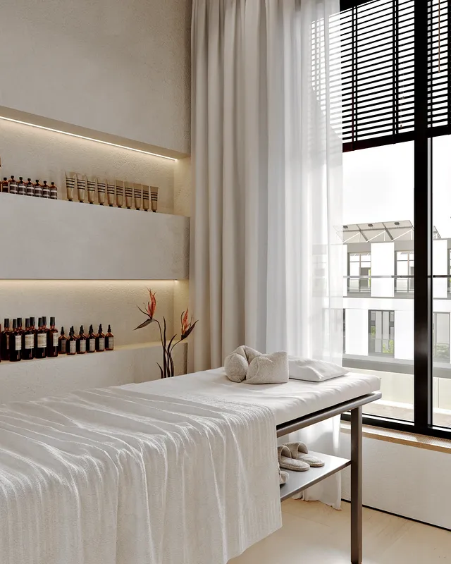 Serene massage room with a window, treatment bed, and product display shelf.
