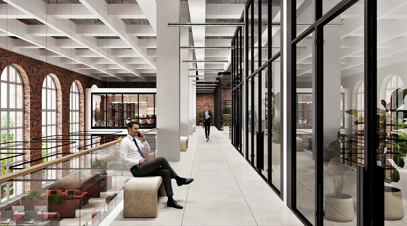 Employee taking a call in the bright second-floor office corridor near executive suites.