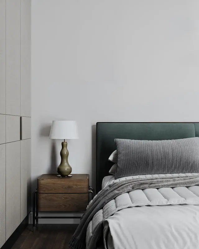 Close-up of a bedside table, lamp, and headboard detail.