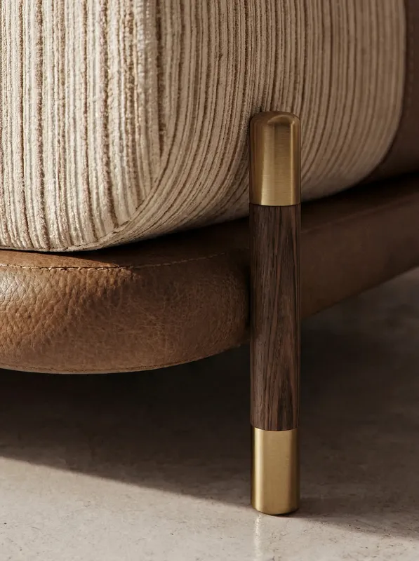 Close-up of the wooden chair leg highlighting leather, metal, and wood textures.