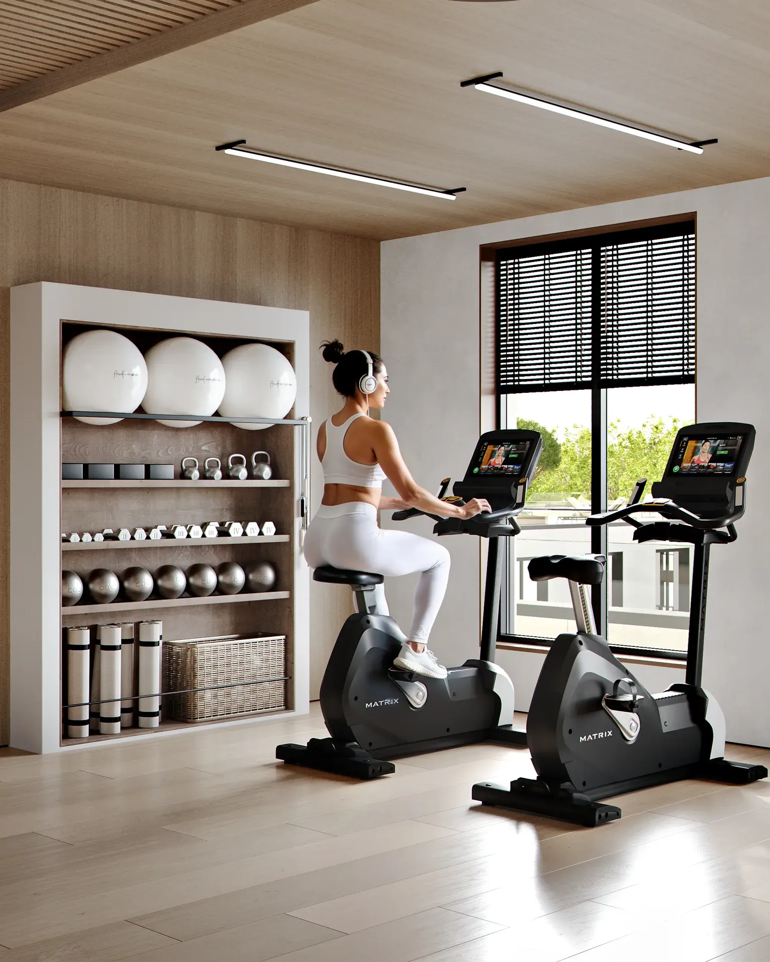 Modern gym interior showing the cardio zone with stationary bikes and equipment shelving.