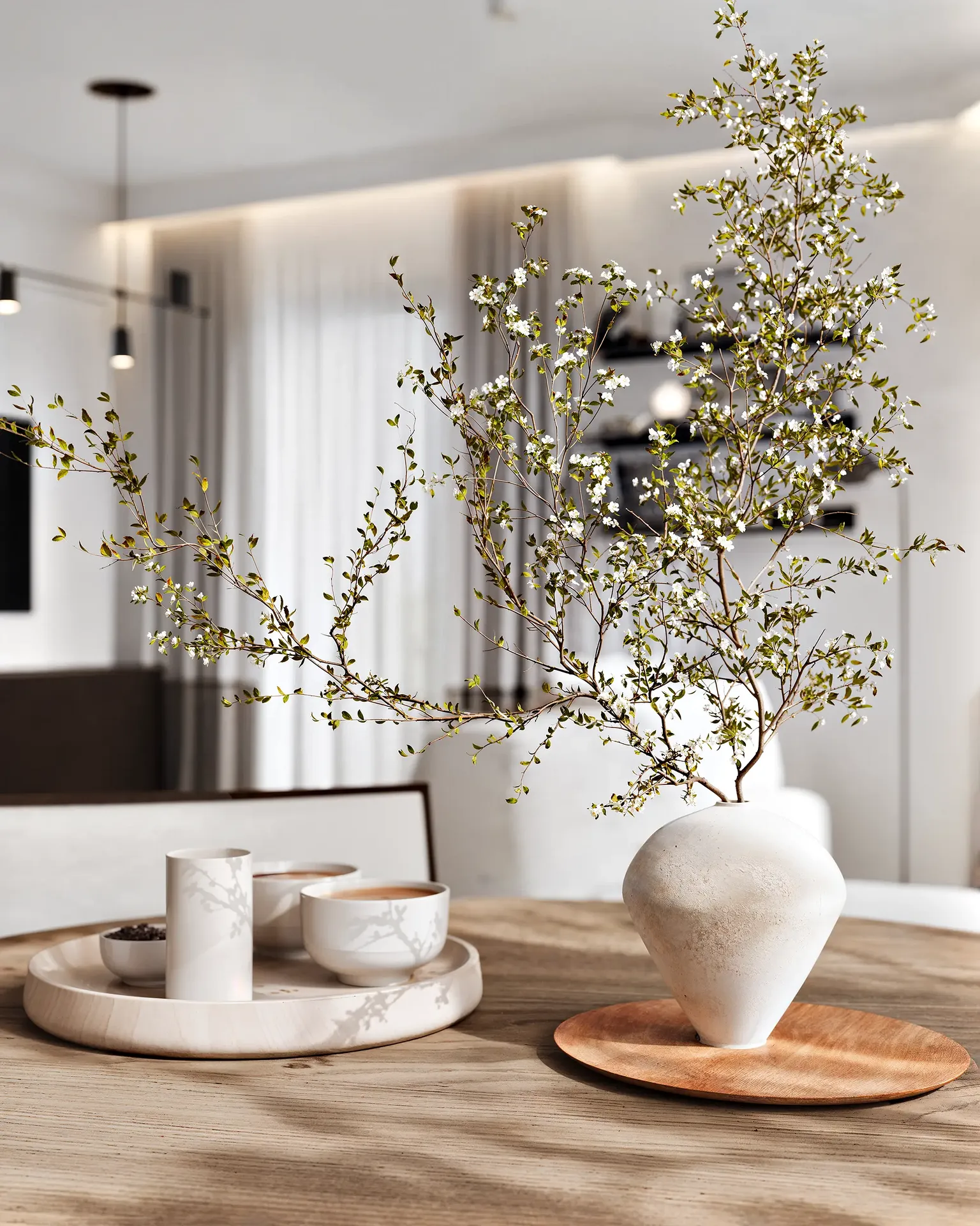 Close-up of an elegant tablescape on a dining table, featuring a modern vase and dishes.
