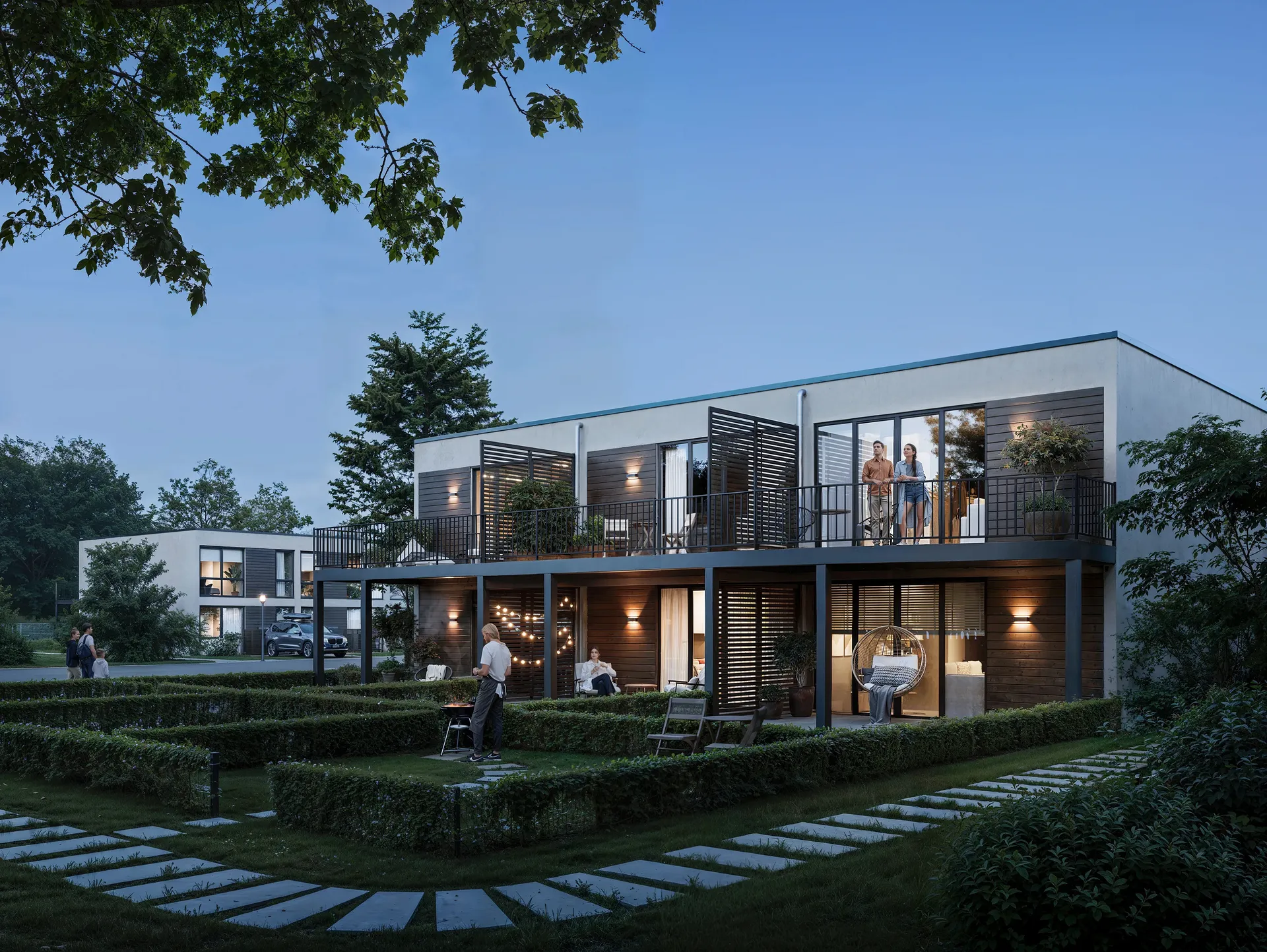 Evening view of a house with residents relaxing on balconies.