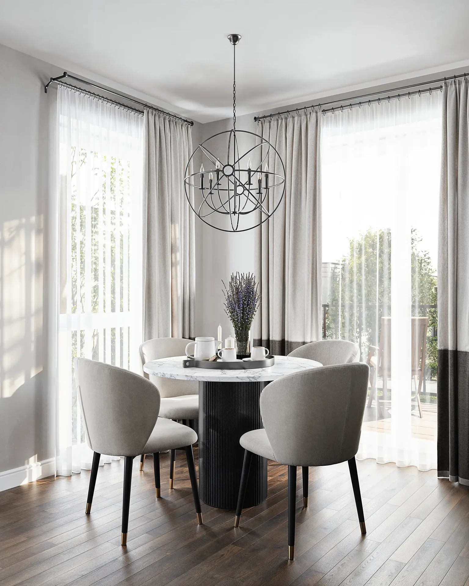 Bright dining area with round marble table and modern orb chandelier.