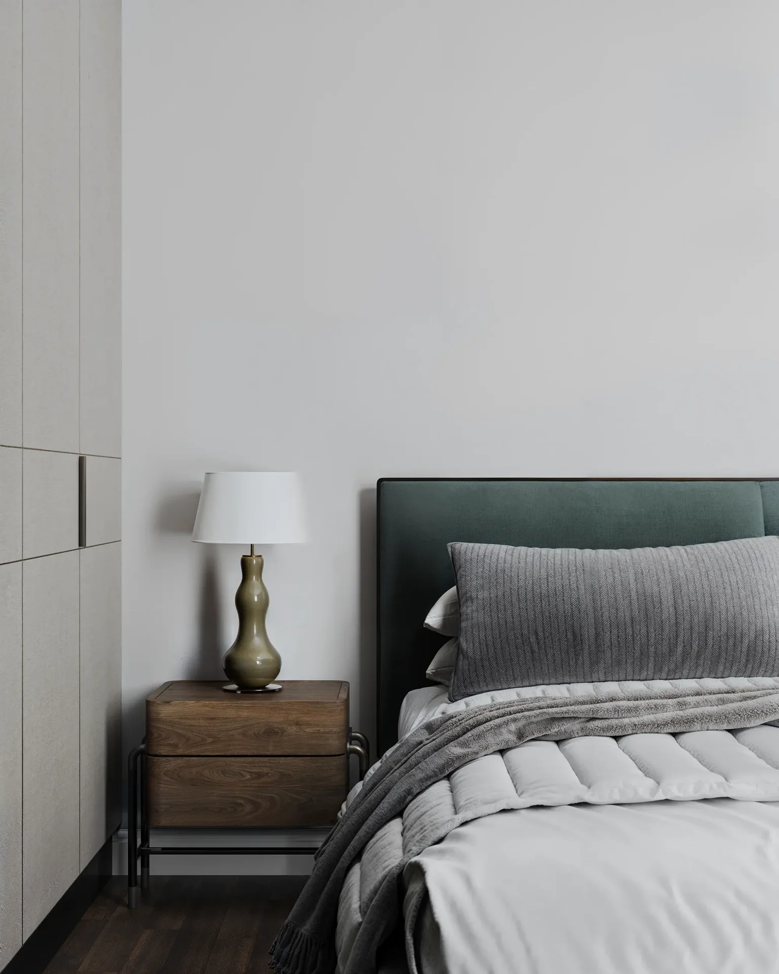 Close-up of a bedside table, lamp, and headboard detail.