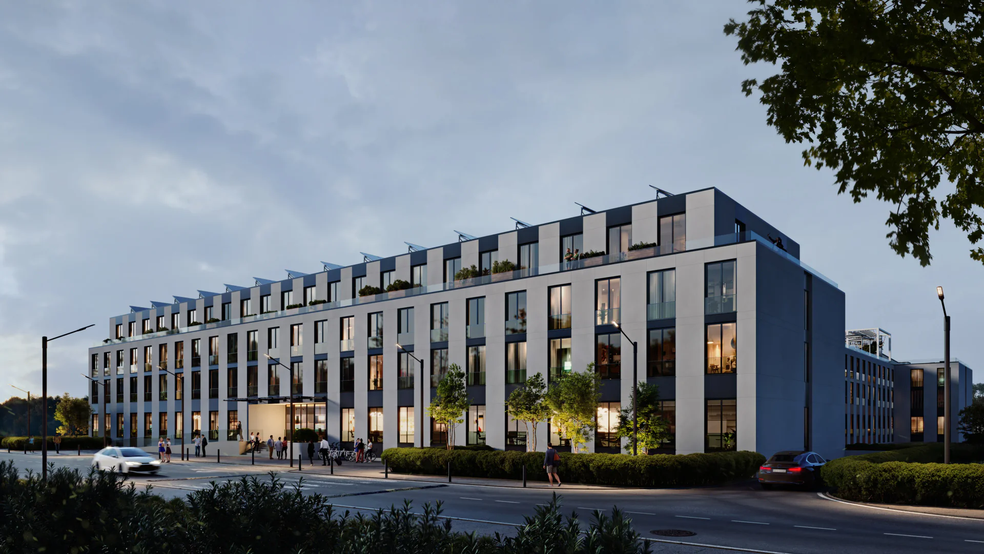 Dynamic corner view of the illuminated residential complex at dusk, highlighting its modern facade.