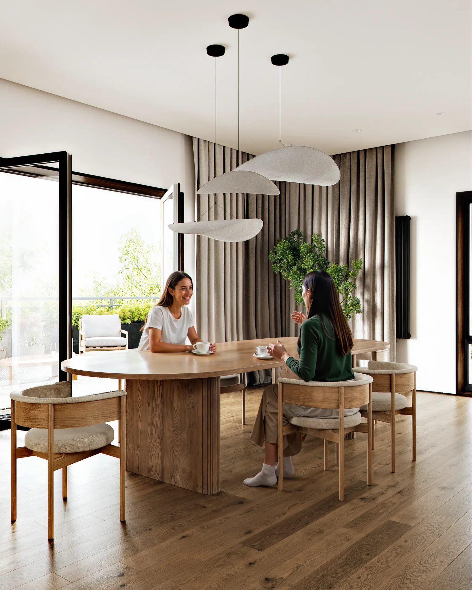 Two women enjoying tea at a modern dining table in a bright, Japandi-style apartment.