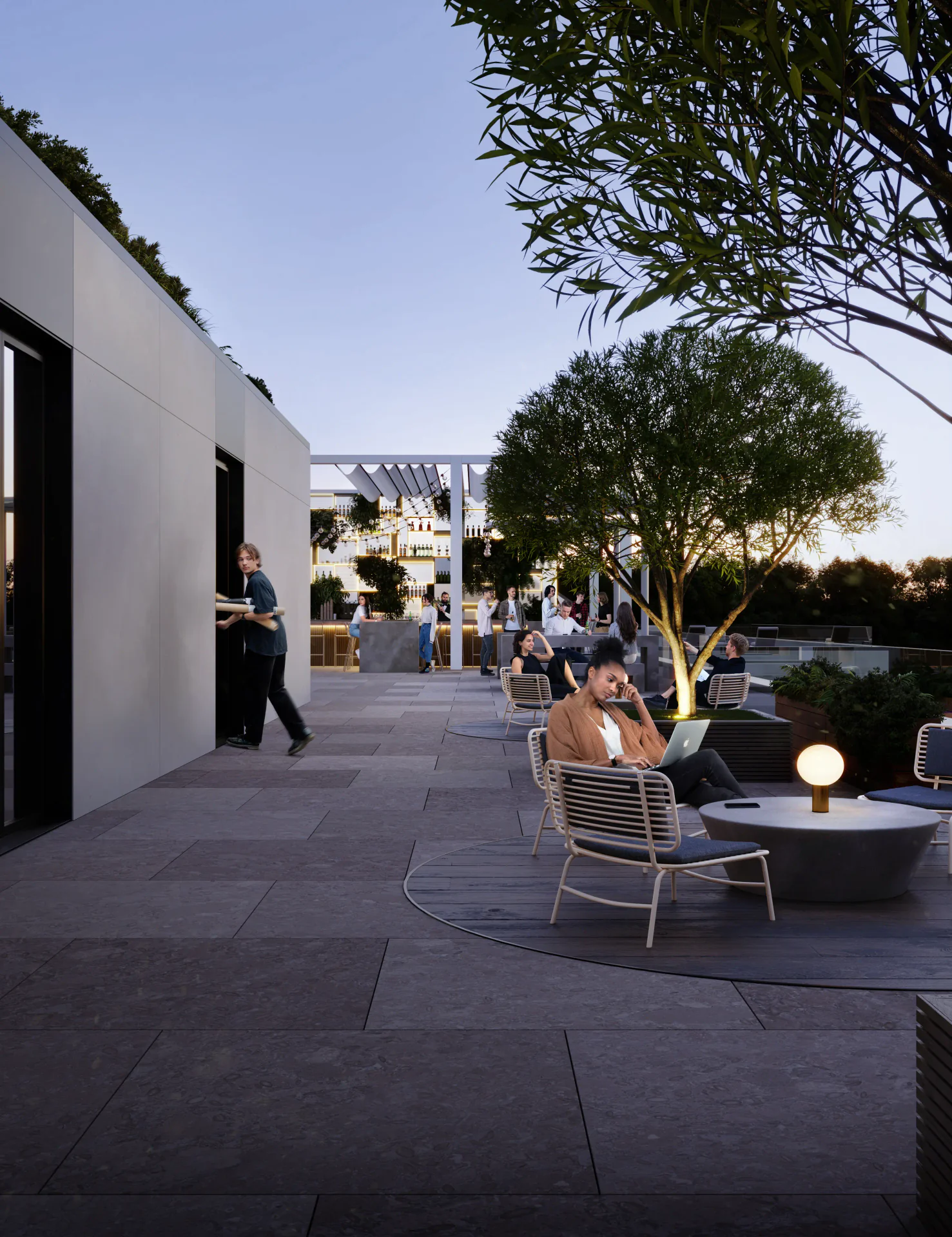 Warmly lit outdoor cafe seating area at night, with empty tables and chairs.