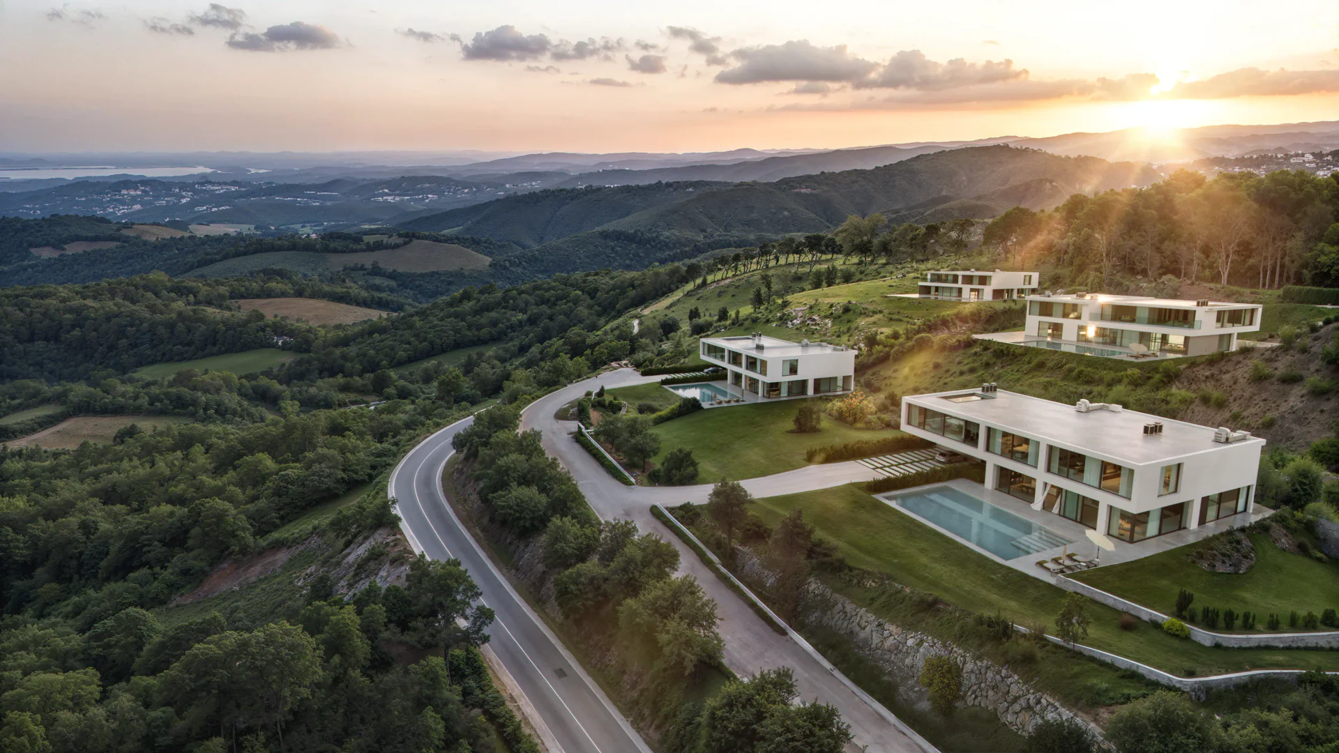 Luxury hillside villa complex glowing in the warm light of a sunset.
