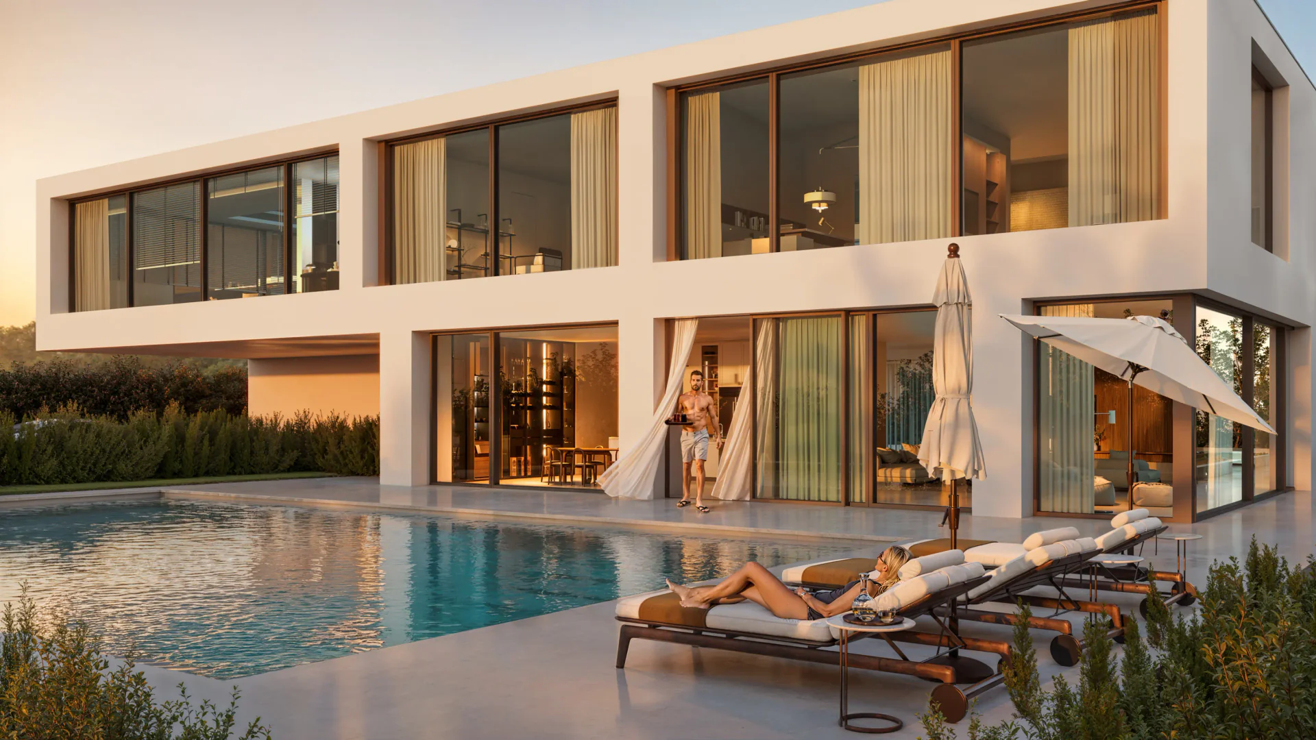 Two-story villa with a pool at sunset, featuring a couple relaxing on the terrace.