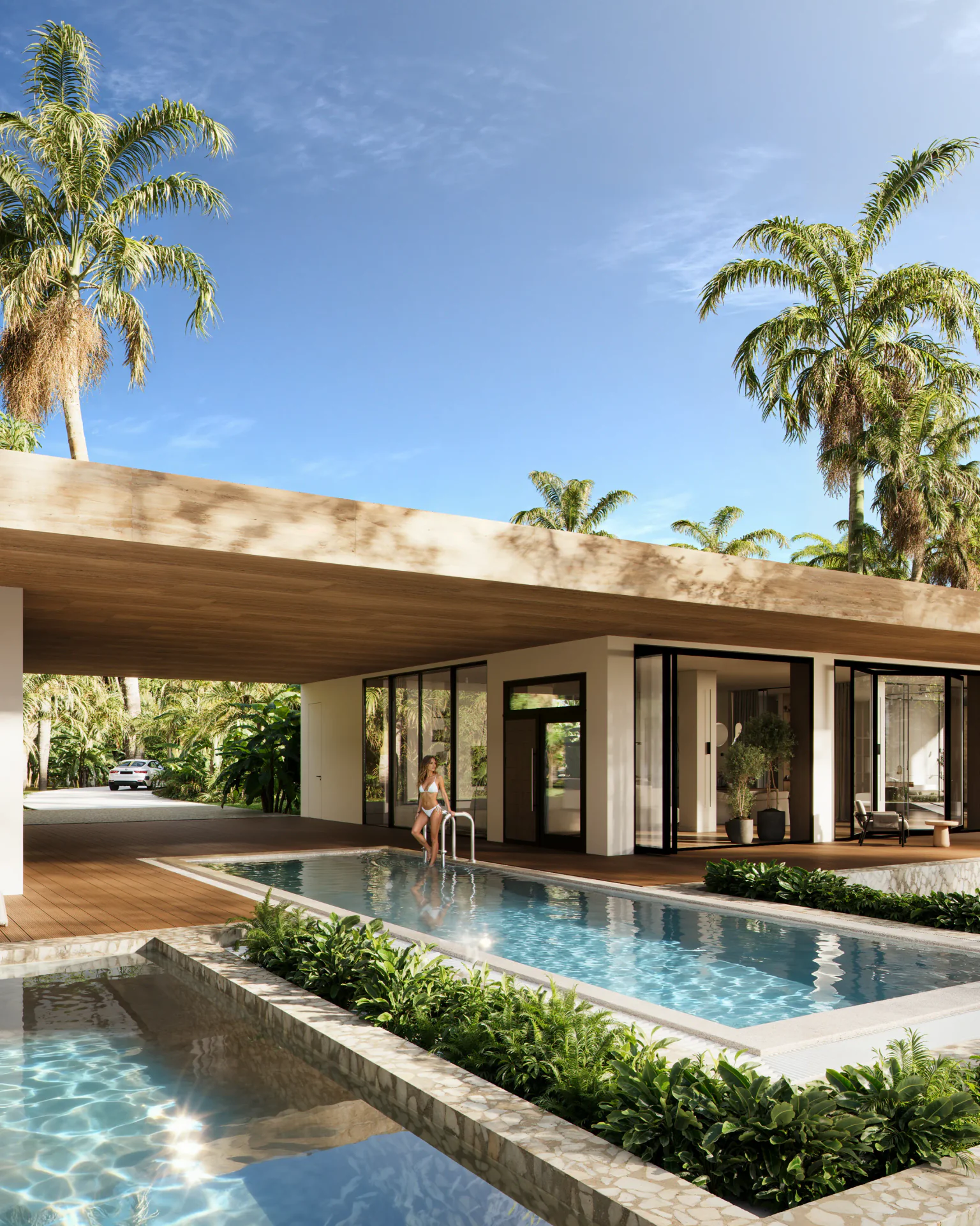 Modern villa entrance and pool area with a woman enjoying the tropical setting.