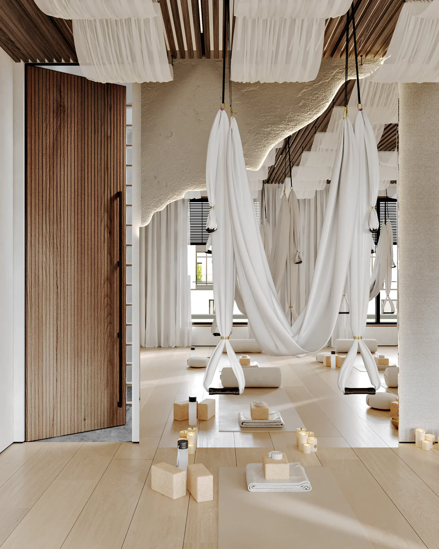 Aerial yoga setup with a hammock by a mirror, near the locker room entrance.