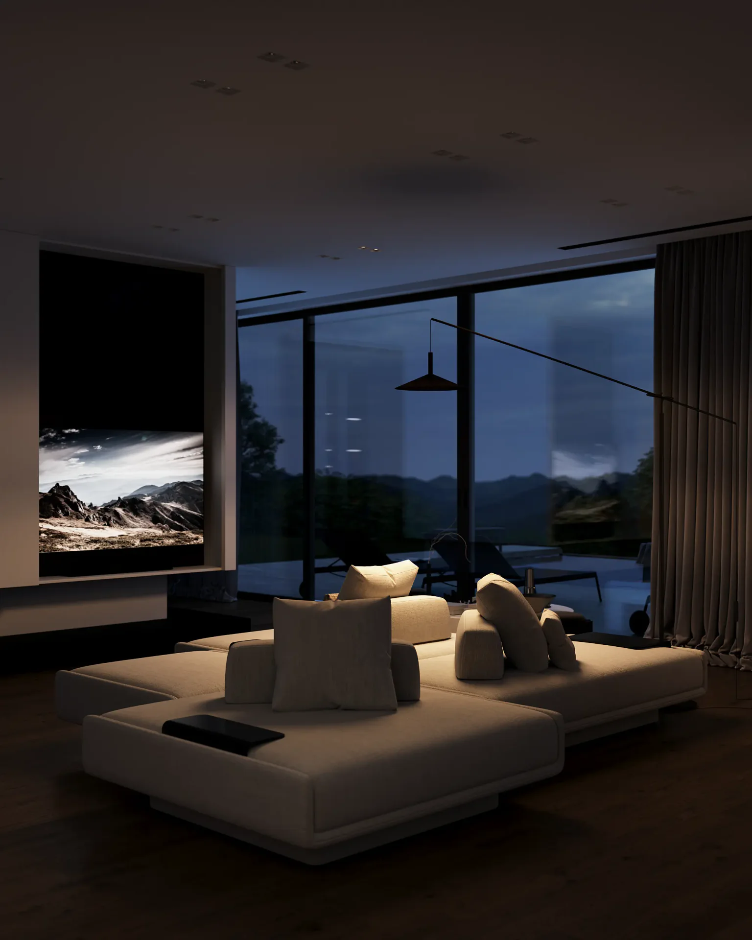 Cozy evening view of the living room, showing the sofa and TV area illuminated by a warm floor lamp.