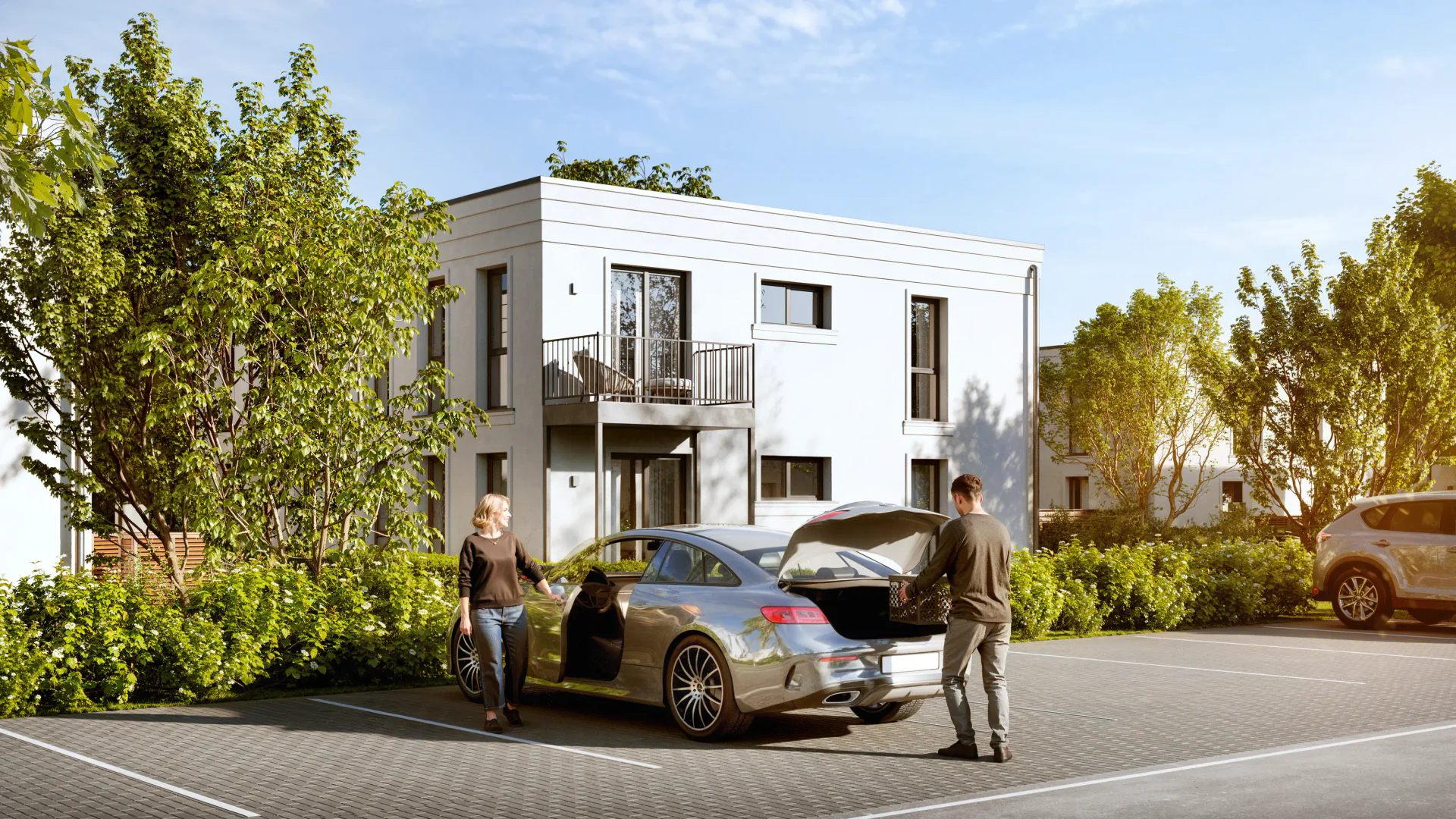 Horizontal view of open-air parking spaces near a modern residential home.