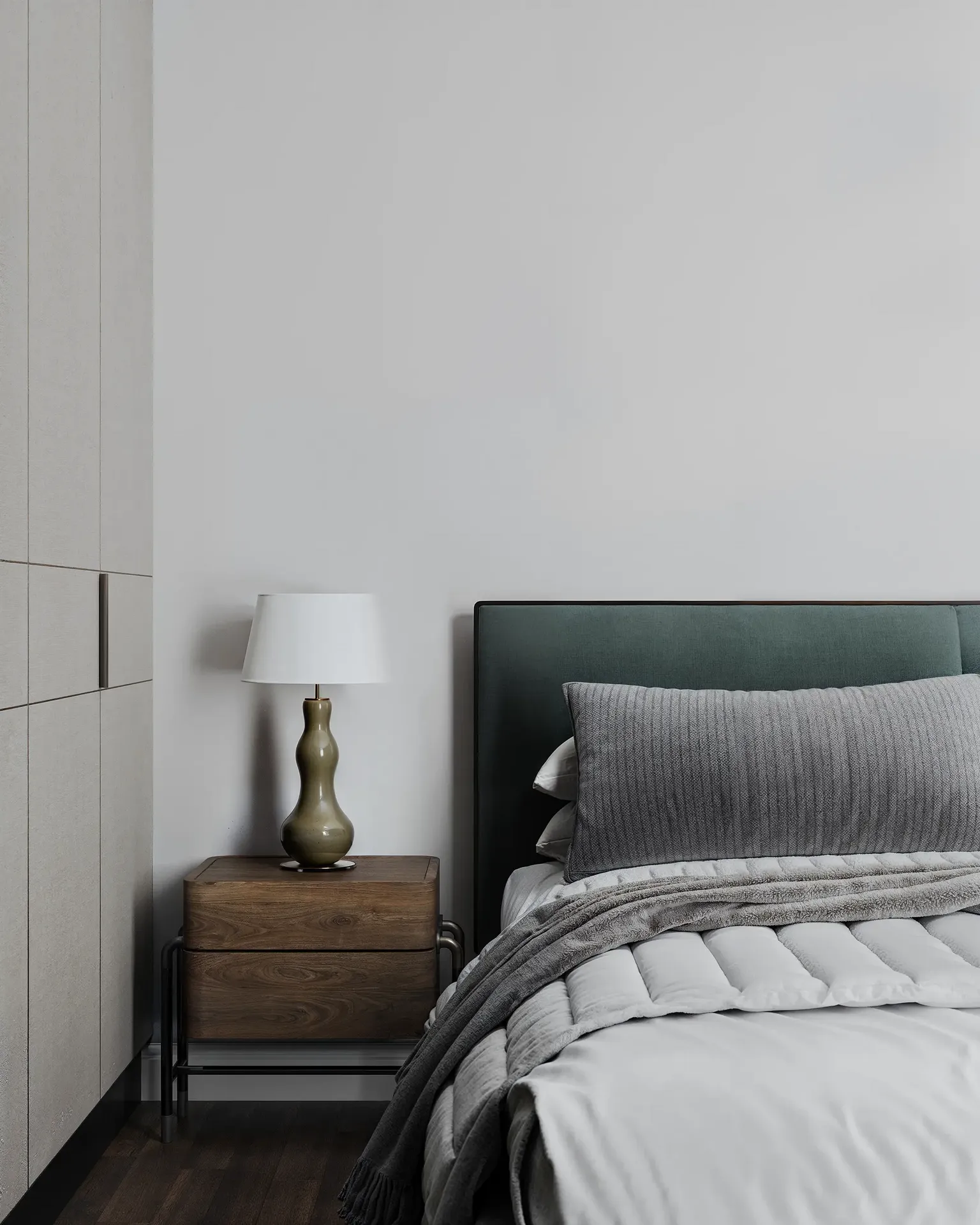 Nahaufnahme eines Nachttisches, einer Lampe und Details am Kopfteil.