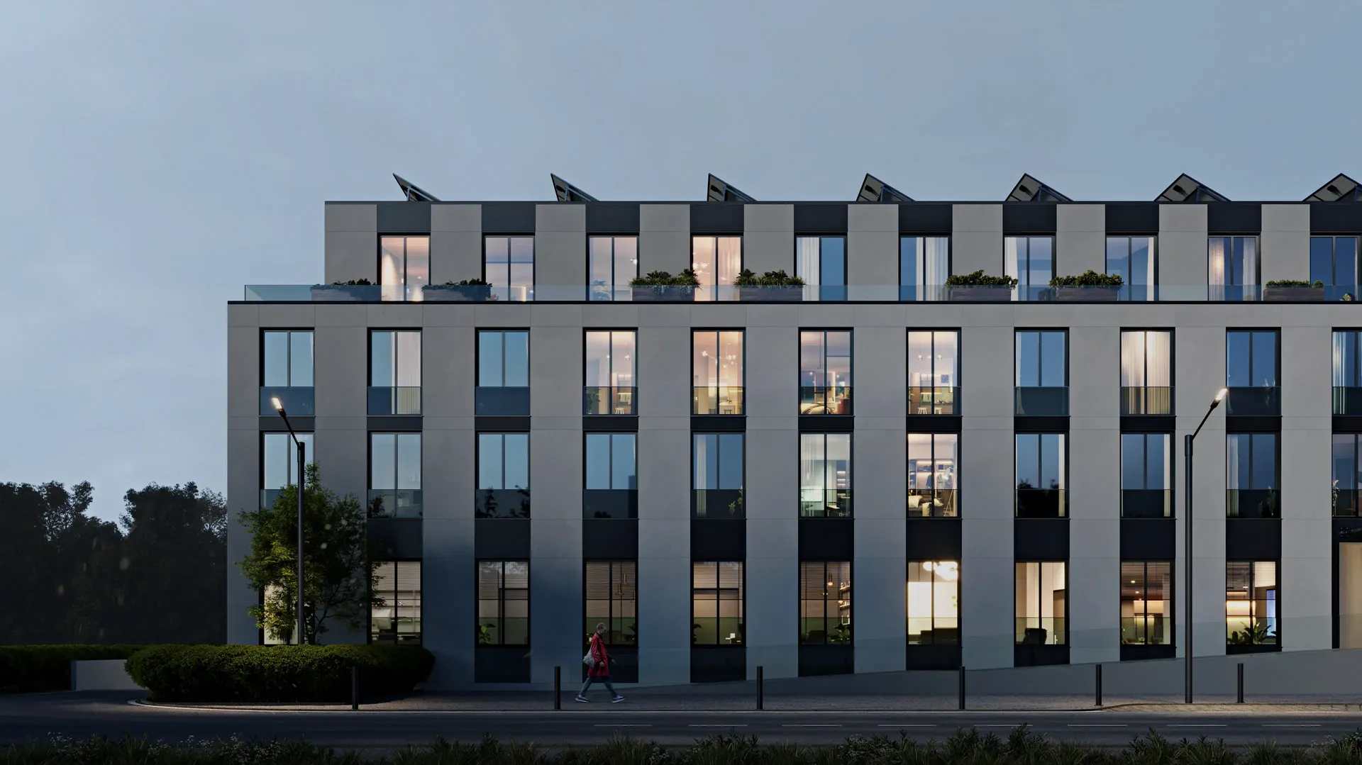 Eindrucksvolle Frontal-Abendaufnahme der modernen Wohnanlage Adlershof, warm beleuchtet.