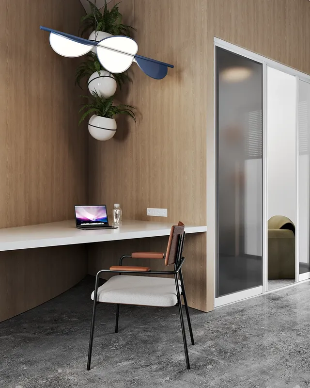 Un comptoir de travail individuel épuré positionné à l'entrée du coin salon du bureau.