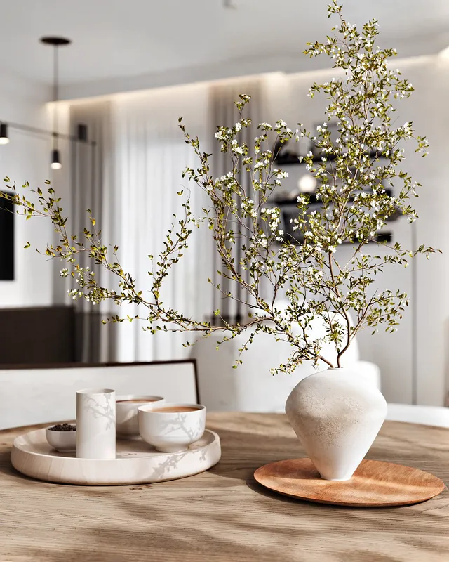 Gros plan d'une table élégante sur une table à manger, comprenant un vase et des plats modernes.