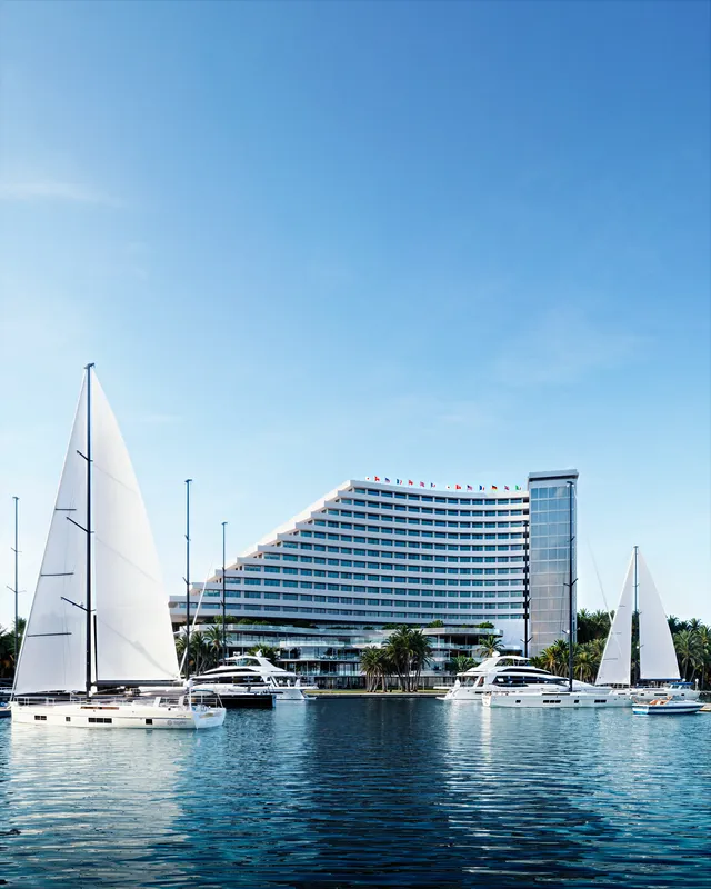 Extérieur de l'hôtel de station balnéaire donnant sur la marina avec yachts et voiliers