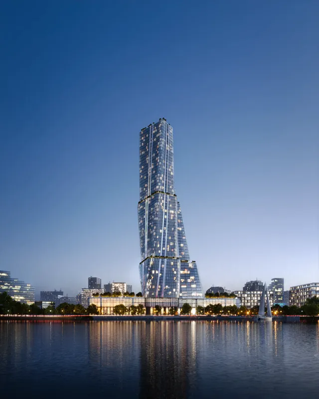 Abendlicher Blick auf einen modernen Wolkenkratzer am Fluss.