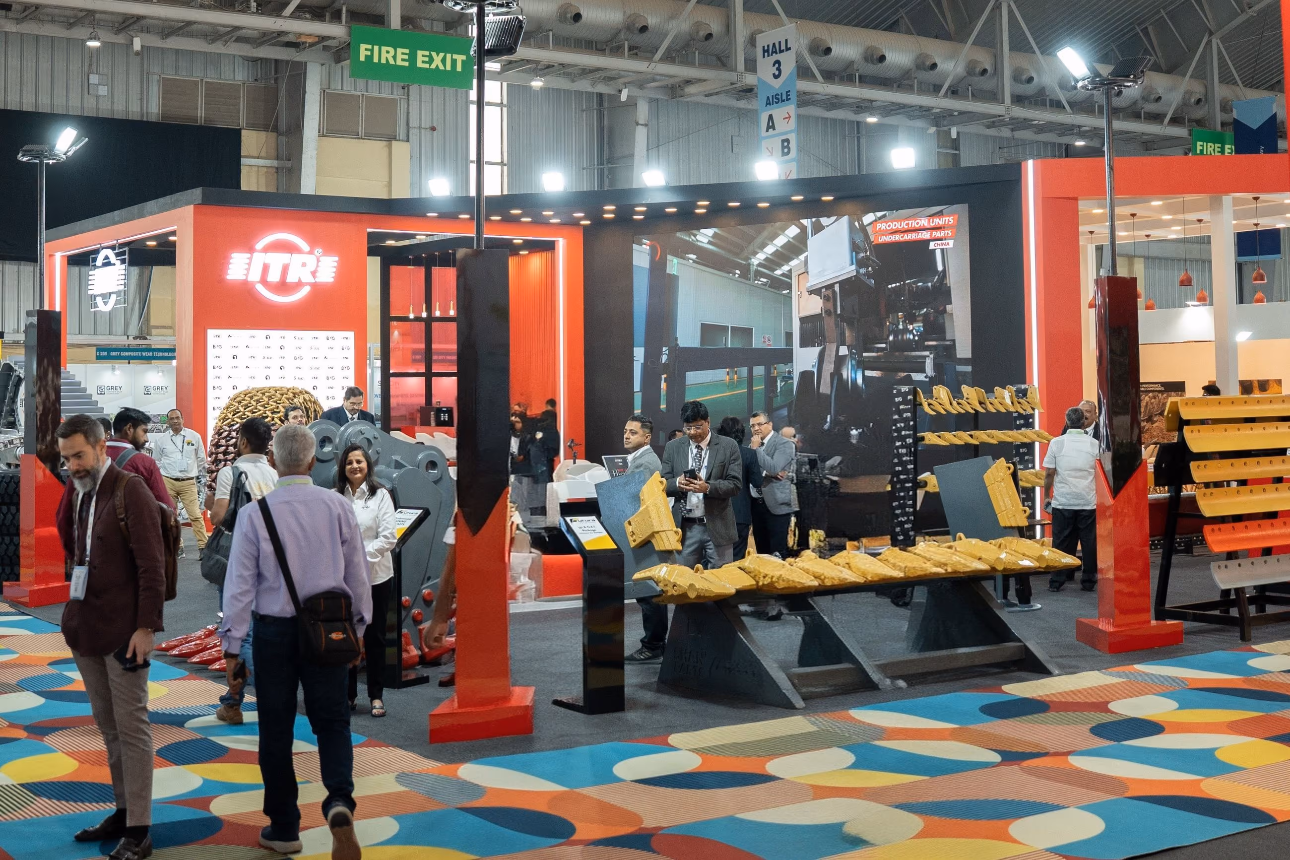 Visitors at a red-branded exhibition stand designed by Blues N Coppers