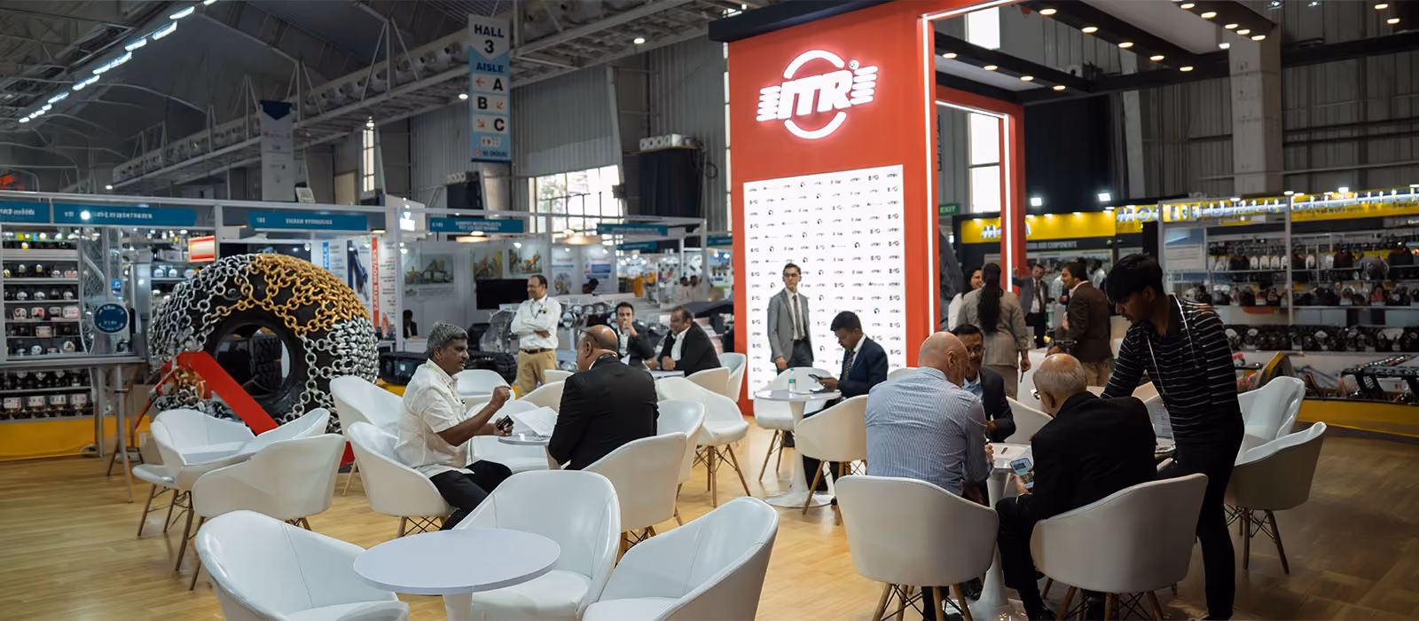 ITR exhibition stand by Blues N Coppers, with a lounge meeting area and a chain-wrapped tyre display in Hall 3