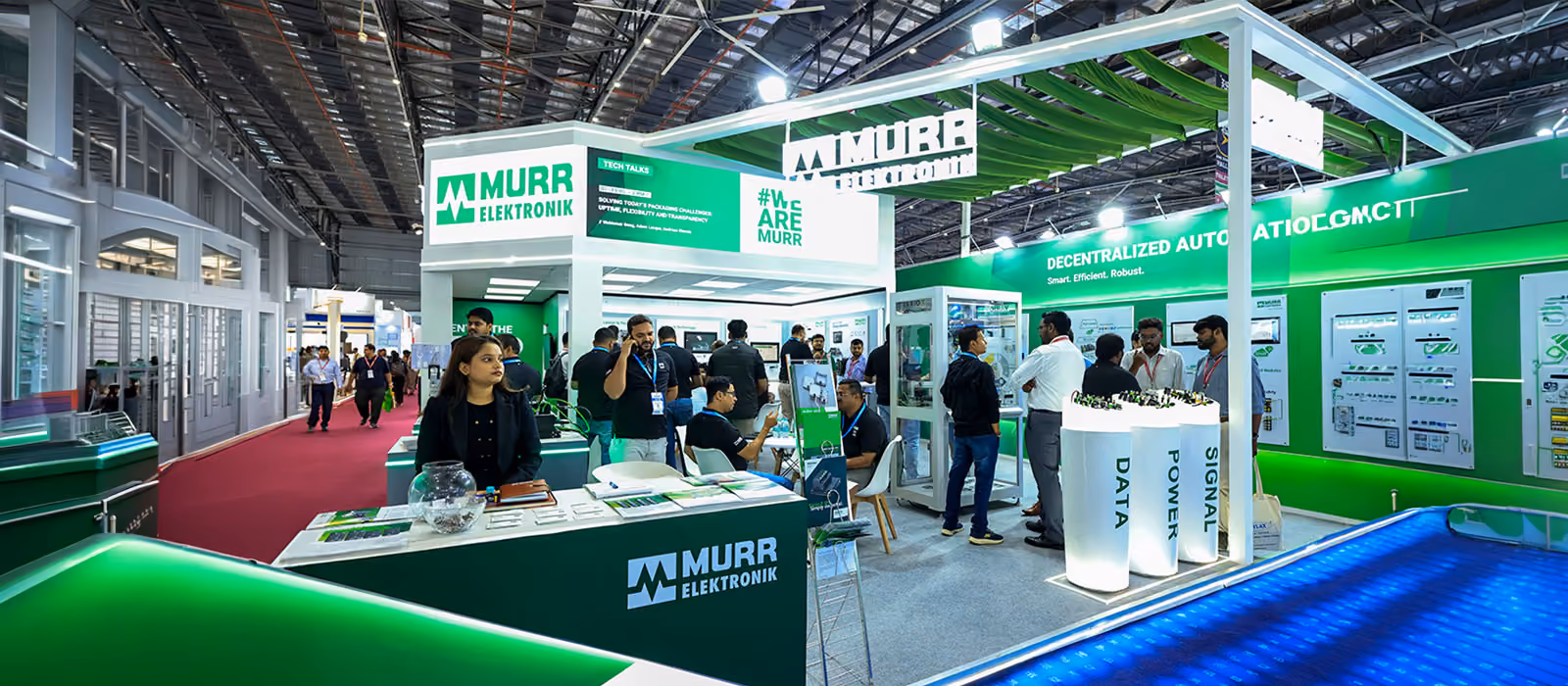 Exhibition stand with green branding and product wall displays, designed by Blues N Coppers