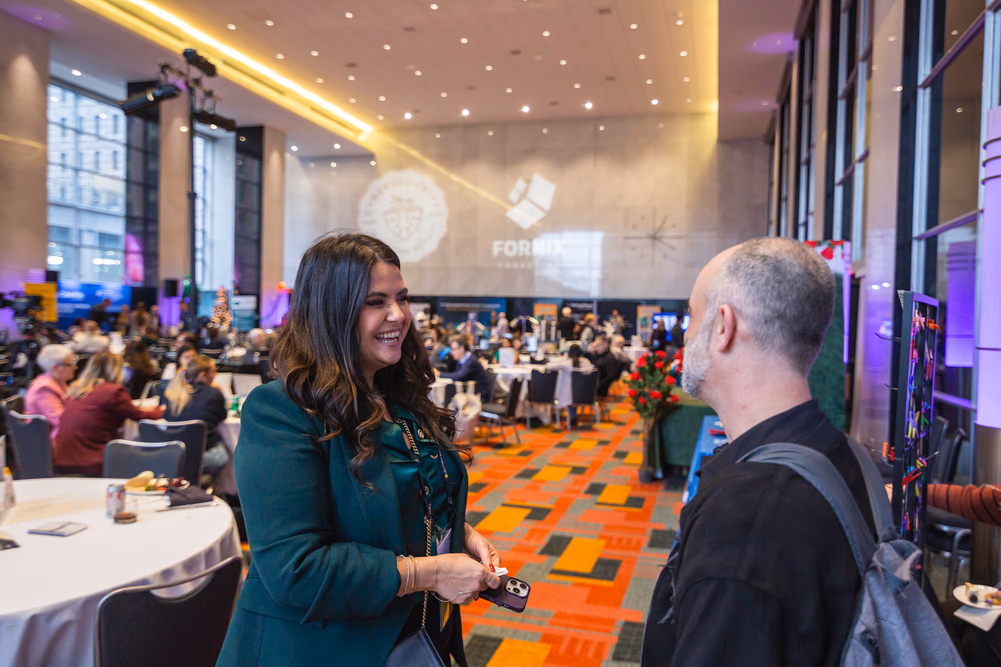 Woman and man talking standing into the side of a conference room