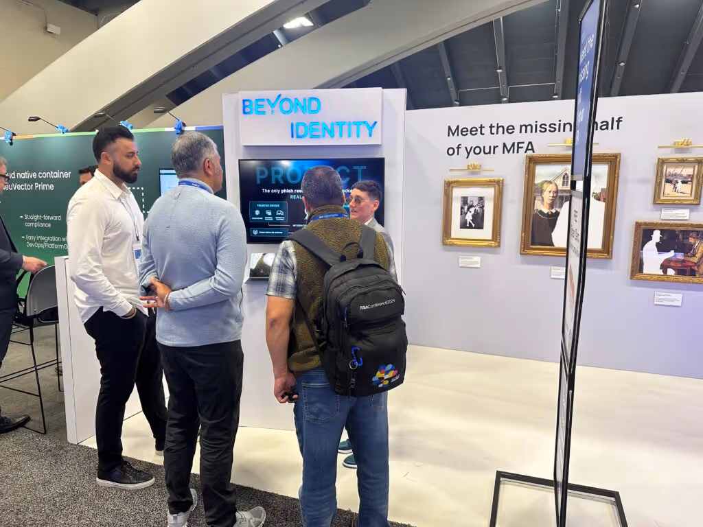 Beyond identity's booth with three men speaking with a representative