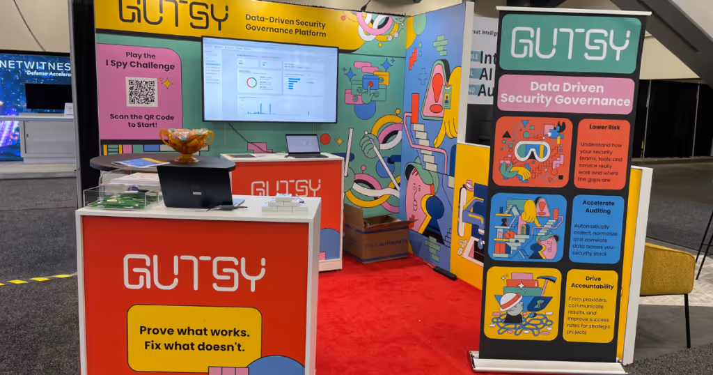 gutsy's boooth with screenwith screen andwith screen and laptopswith screen and laptops on tablewith screen and laptops on tables and gutsy merchandise
