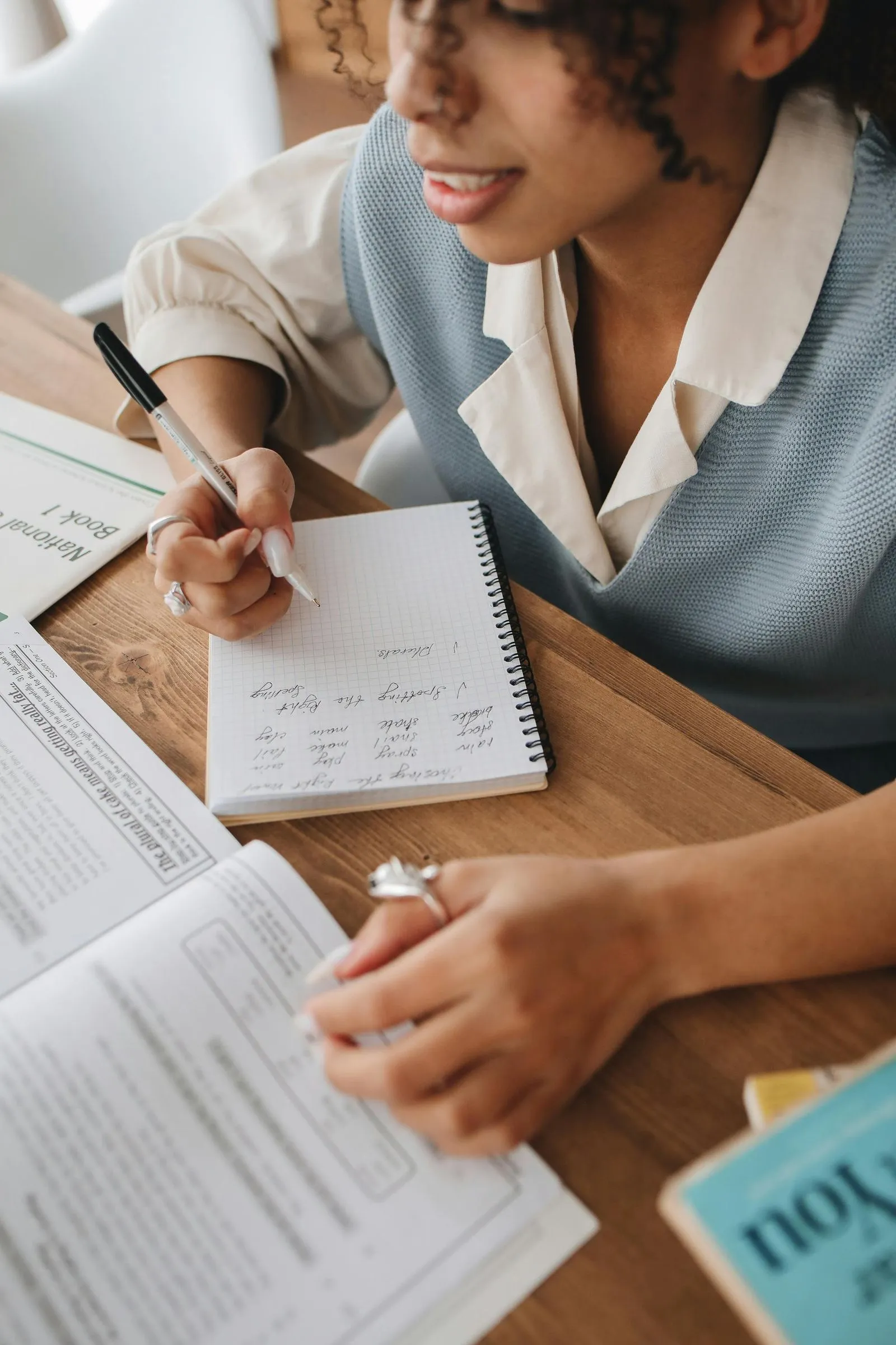 A student is writing in a notebook, concentrating on her work