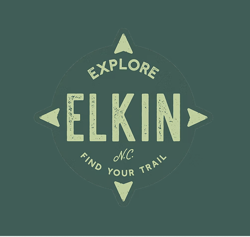 Historic Main Street in Elkin, NC with shops, local art, and visitors walking under string lights