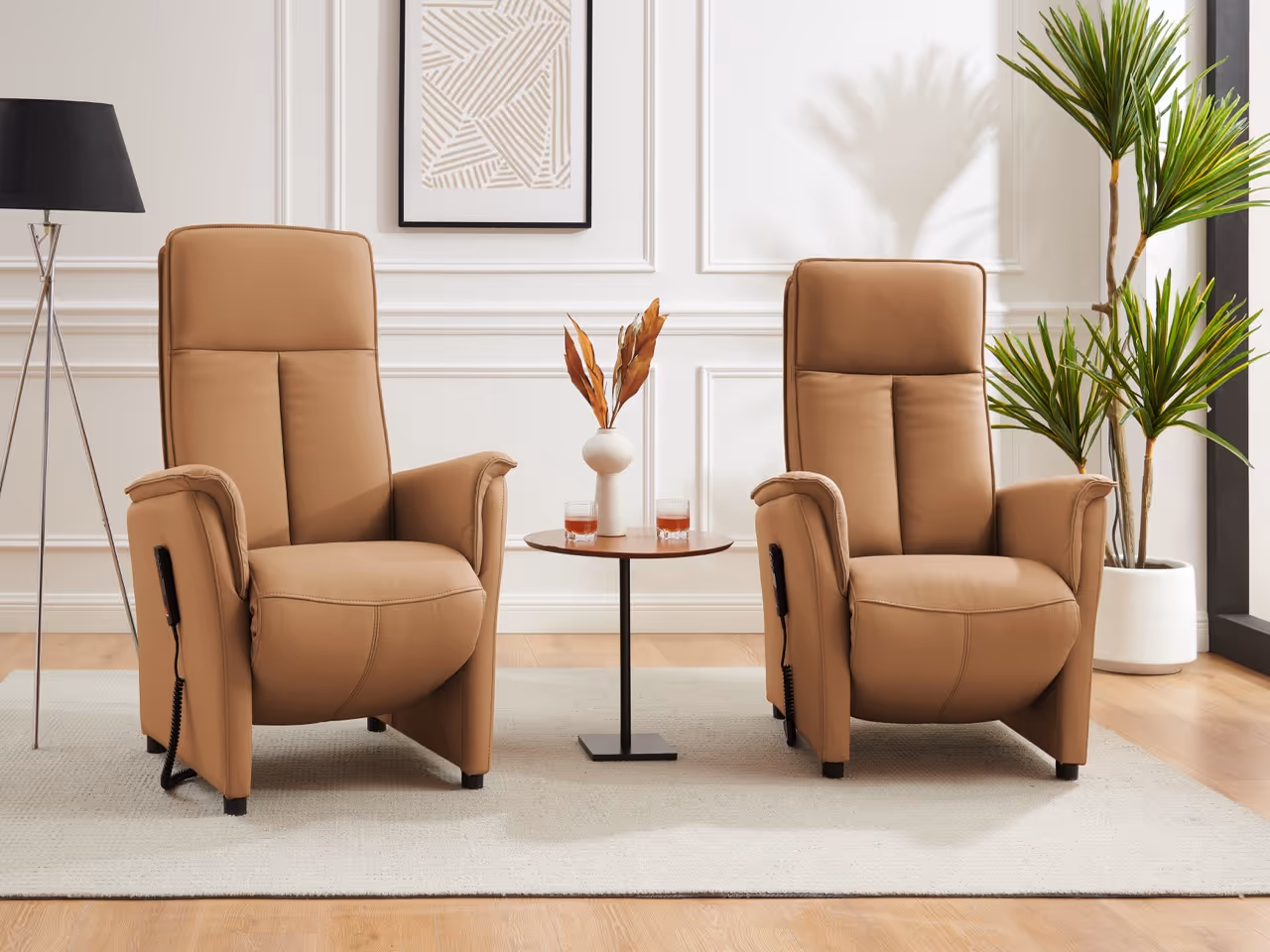 Twee beige relaxfauteuils met een ronde tafel ertussen, zwarte vloerlamp links en grote groene plant rechts in een moderne woonkamer.