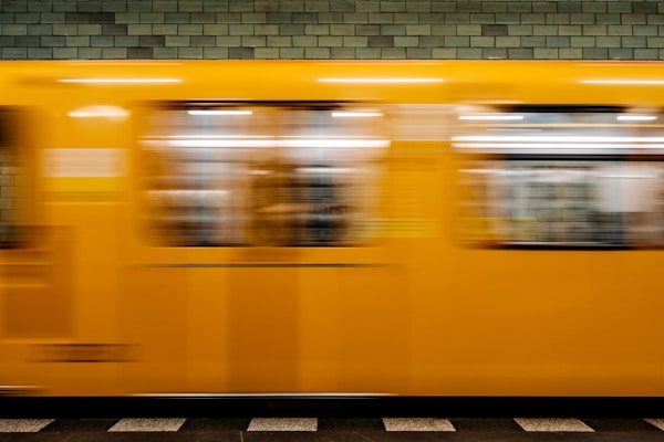 a yellow train traveling past a train station