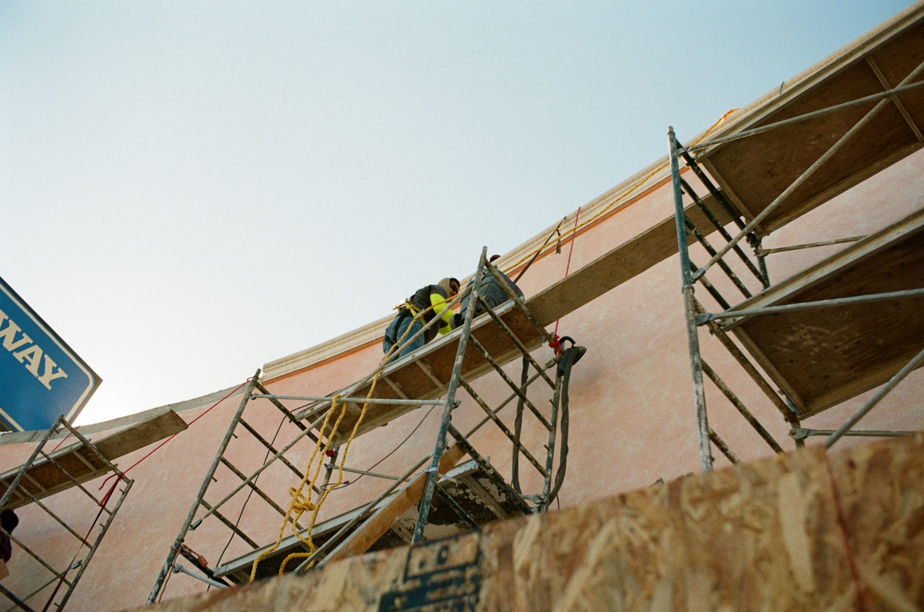Professional man in a blue suit standing outdoors near a construction site.