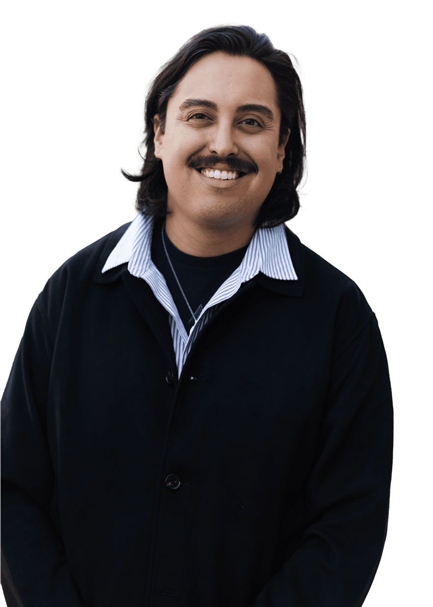 Smiling person with long hair wearing black coat and striped shirt