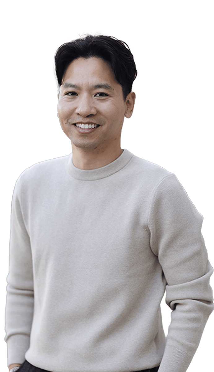 Smiling person in light gray sweater against neutral background