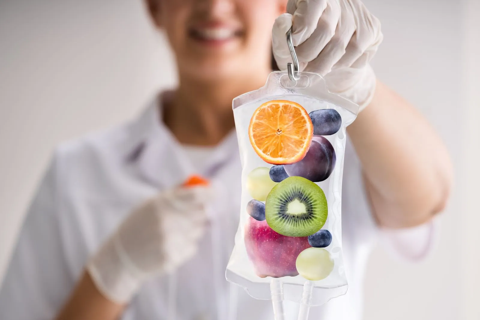 A person in white gloves holding a bag of fruit.