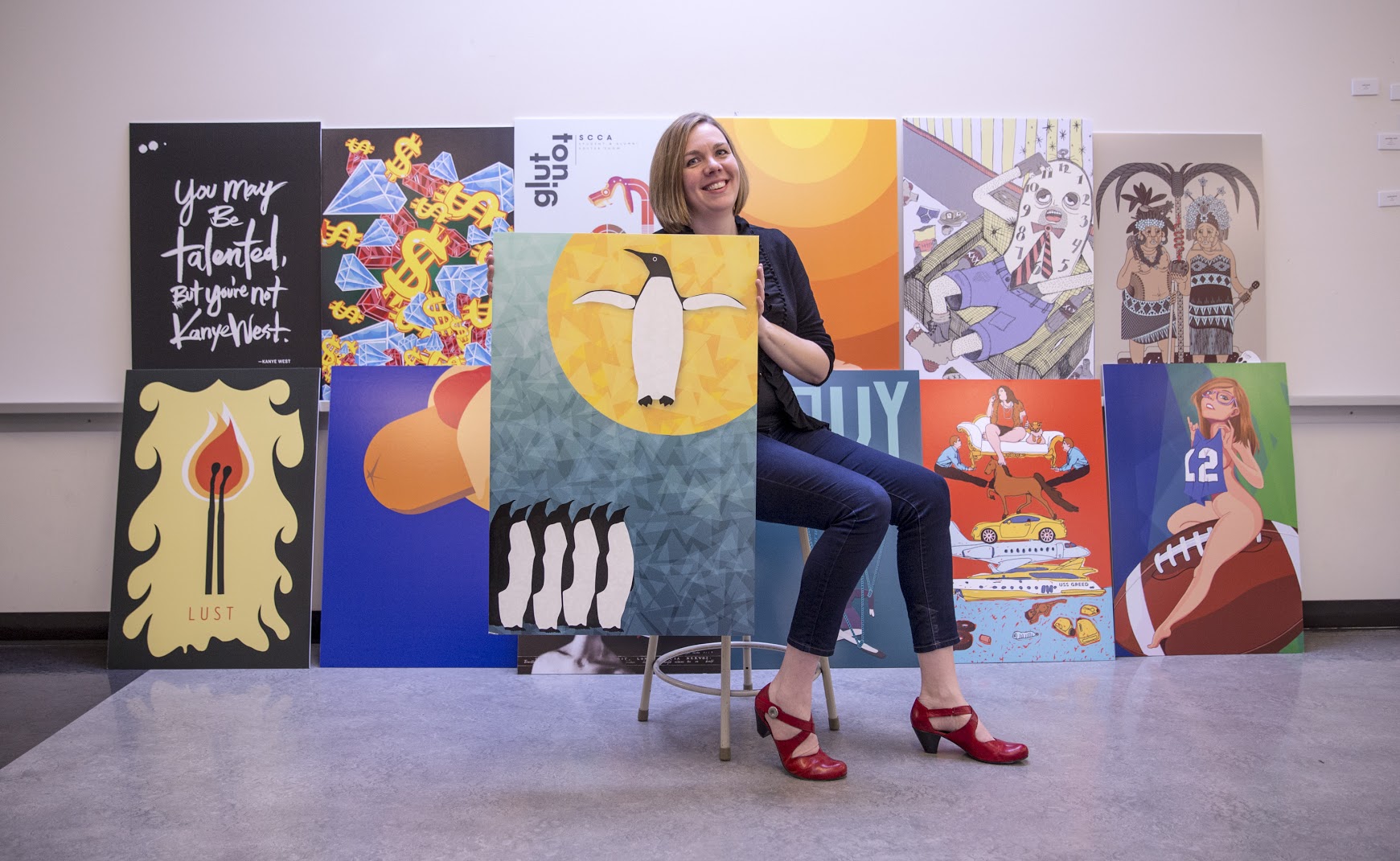 McNamara in front of the results of the student and alumni poster show: Beer and Sin.