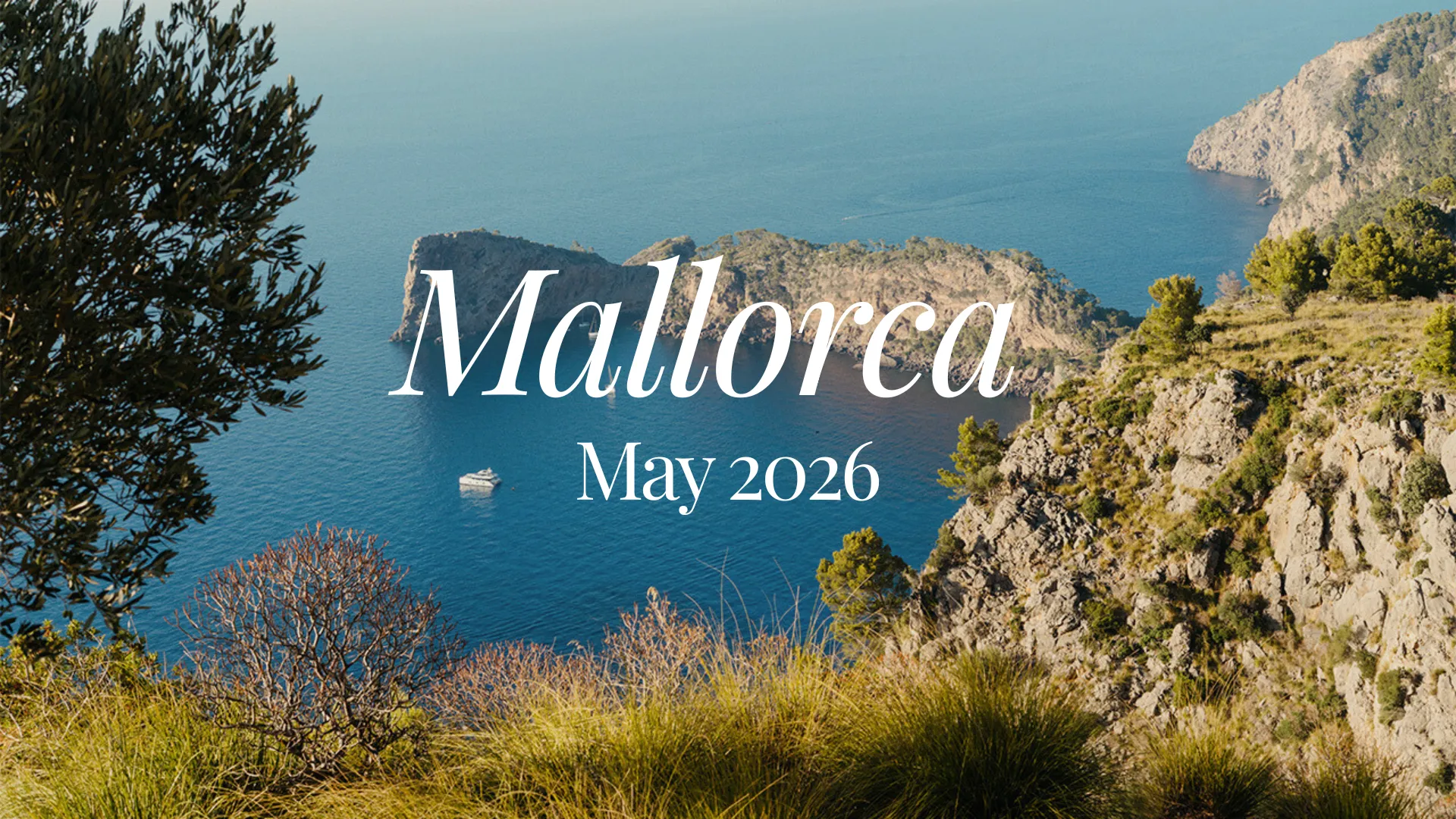 Mallorca retreat 2026 - view of rocky cliffs and blue sea with a boat near Mallorca, May 2026.