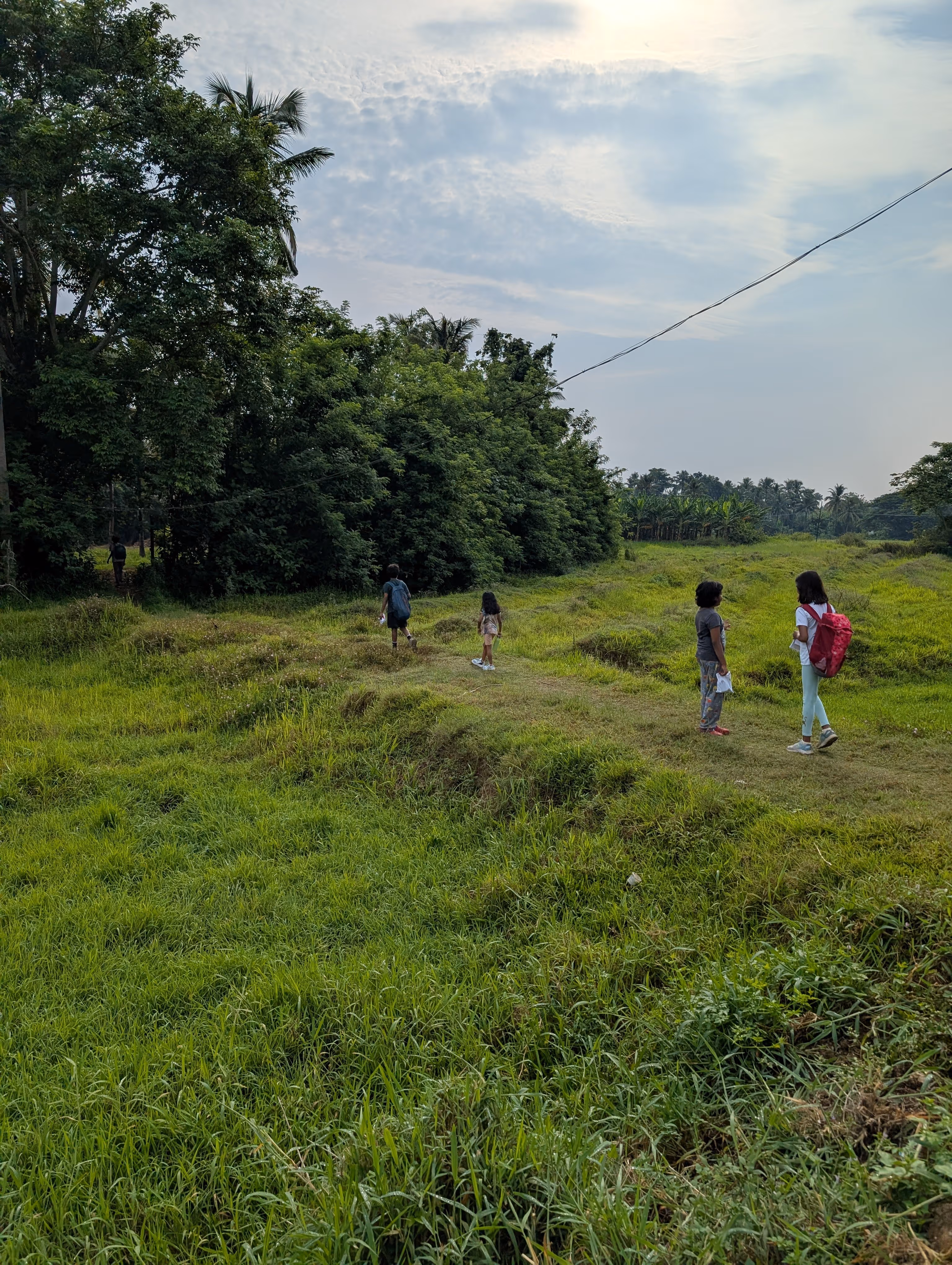 Kids walking through a village field