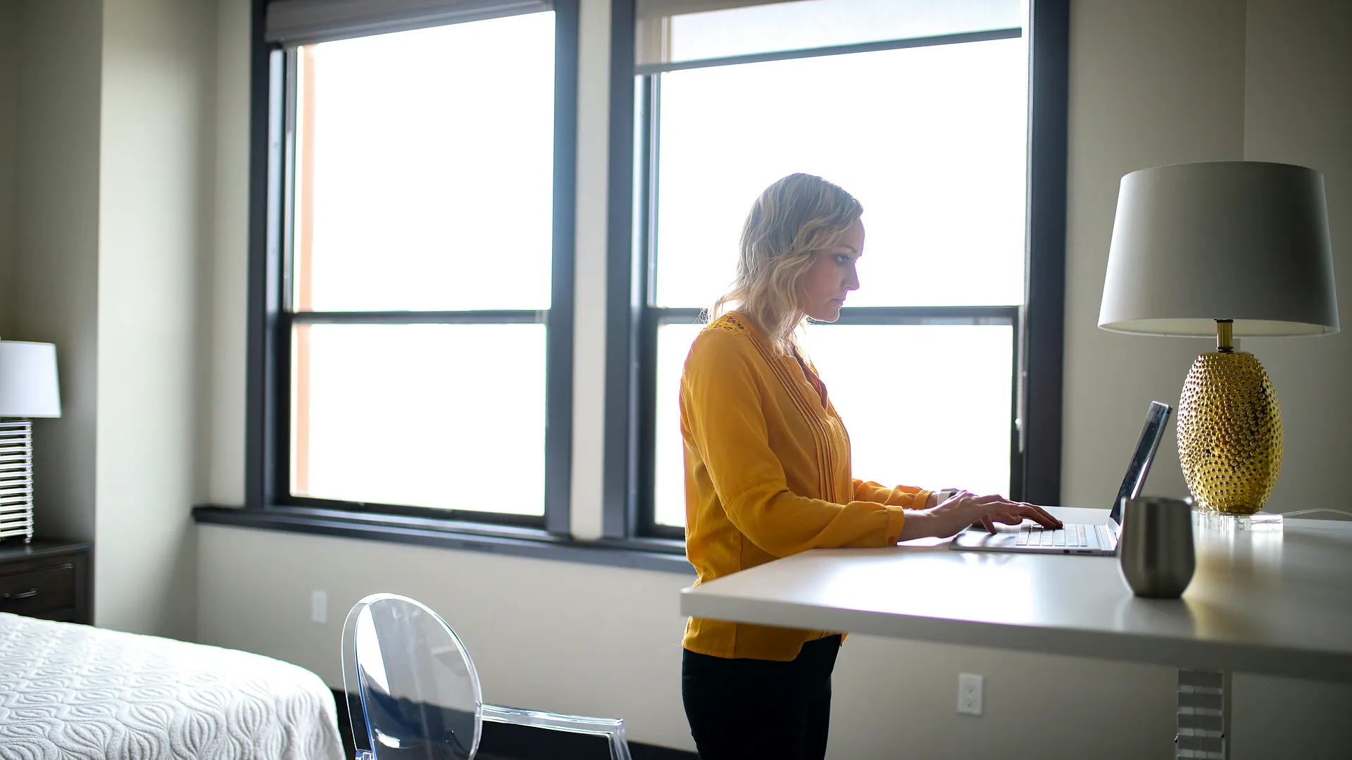 Person working remotely at a standing desk in a bright home office