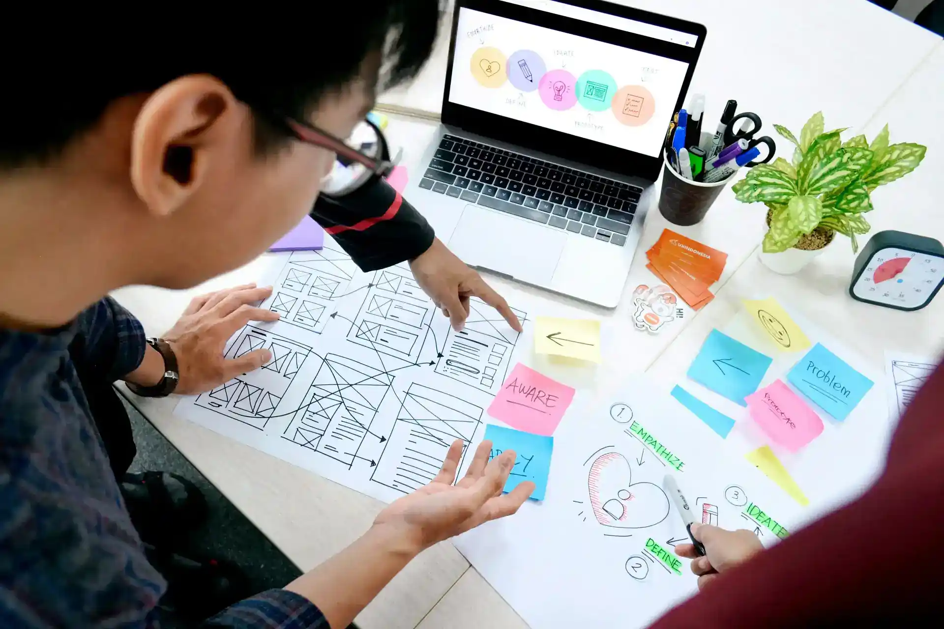 UX designer collaborating on wireframes, user flows, and interface planning for a digital product design project.
