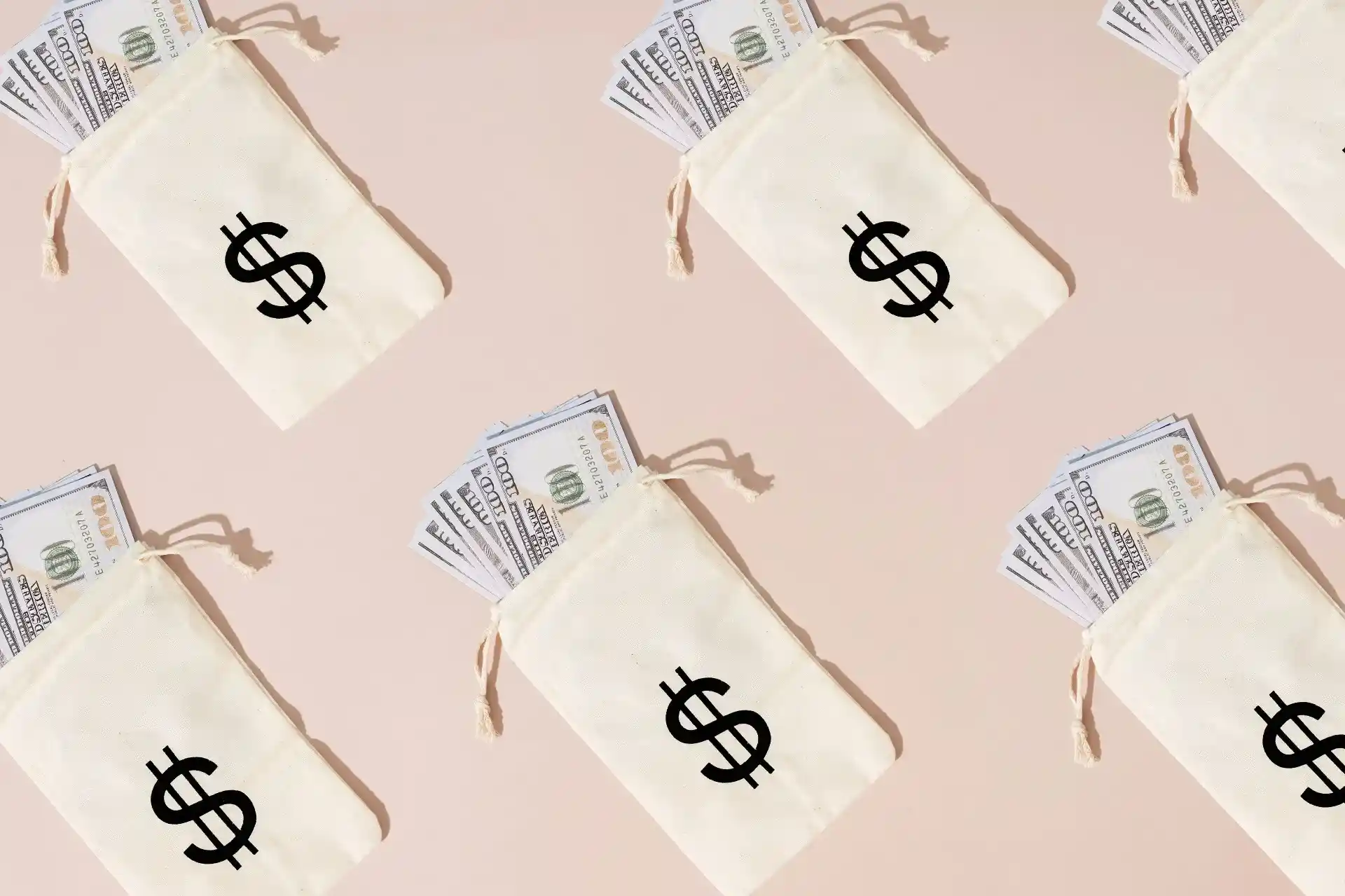 Money bags filled with US dollar bills representing global hiring costs, payroll budgeting, and international workforce expansion.
