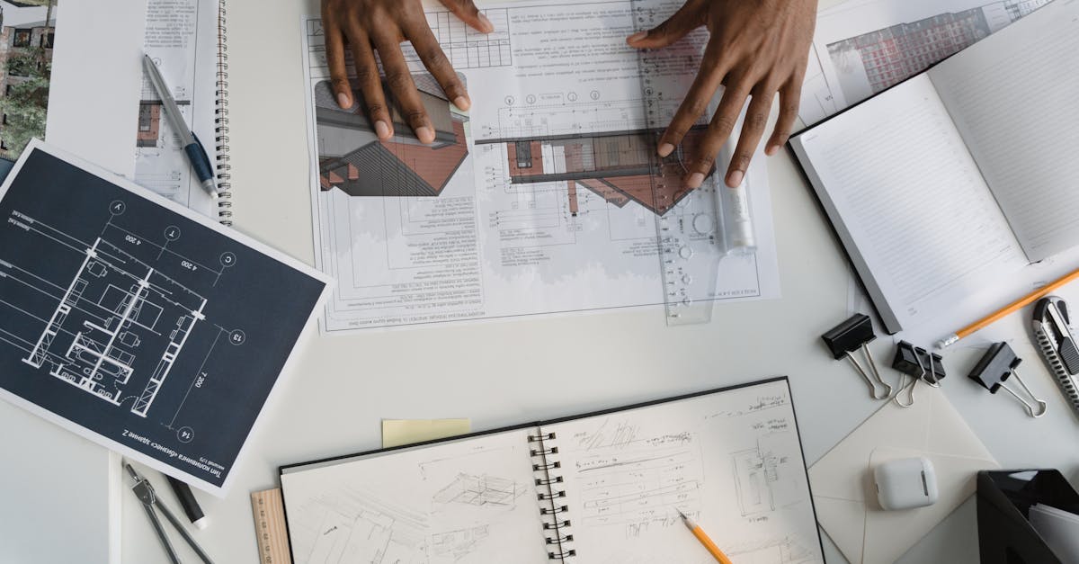Architect analyzing blueprints and sketches at a modern workspace.