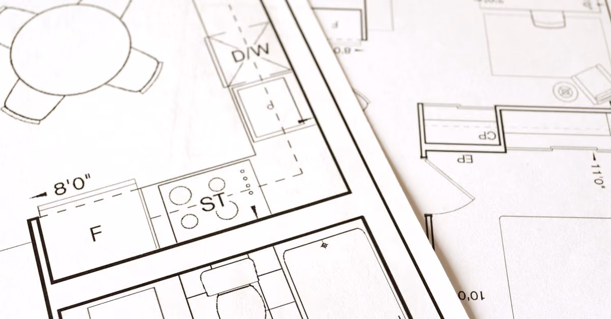 Close-up view of an architectural floor plan on paper showcasing detailed room layouts and measurements.