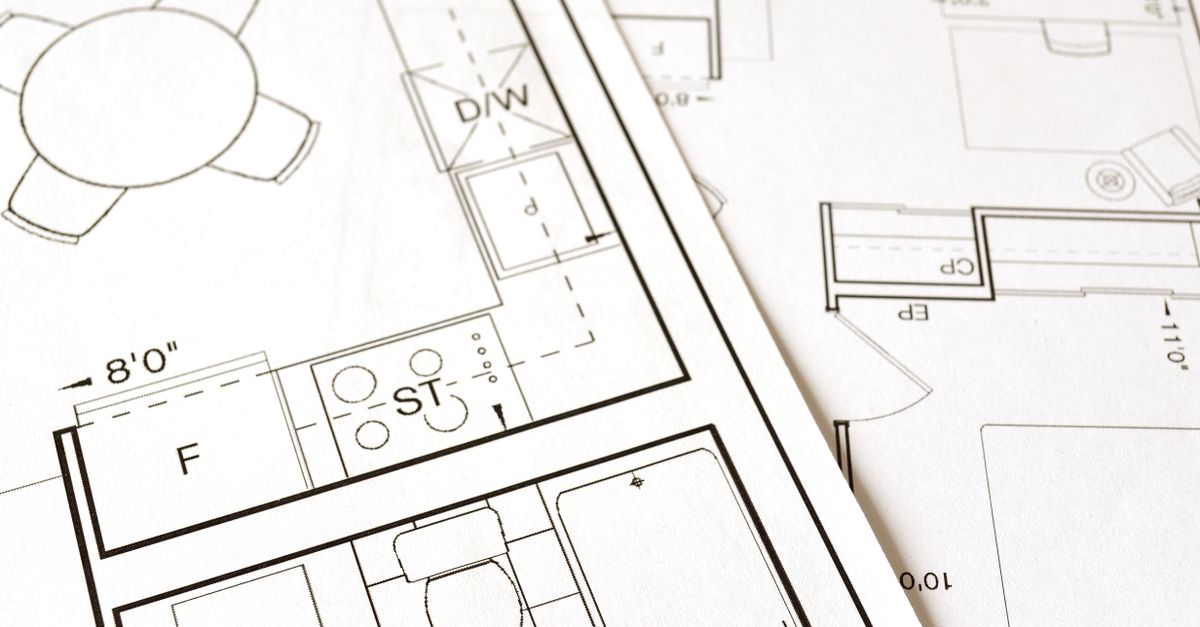 Close-up view of an architectural floor plan on paper showcasing detailed room layouts and measurements.