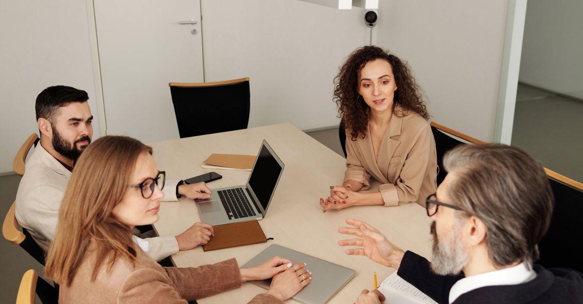 Professional team engaged in a meeting at a modern office table, discussing business strategies.