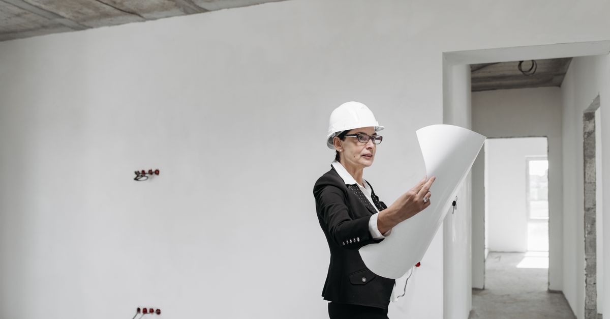 Professional female architect examining construction plans in a modern building