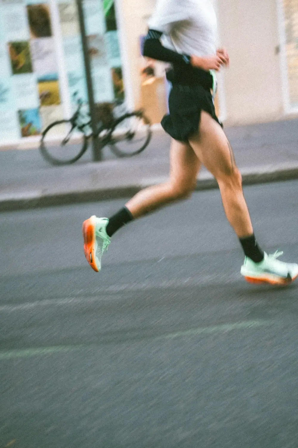 A runner mid-stride on a city street, shot on film